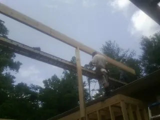 Carpenter setting a ridge beam over a new addition frame — Ice Dam Removal by Roofing Brothers in Tulare