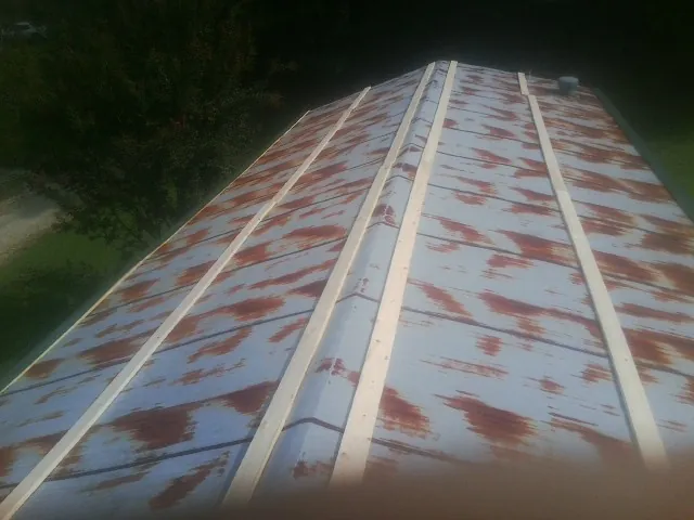 Rusted metal roof panels with new wood purlins before replacement — Storm Damage Roof Repair in Tulare by Roofing Brothers