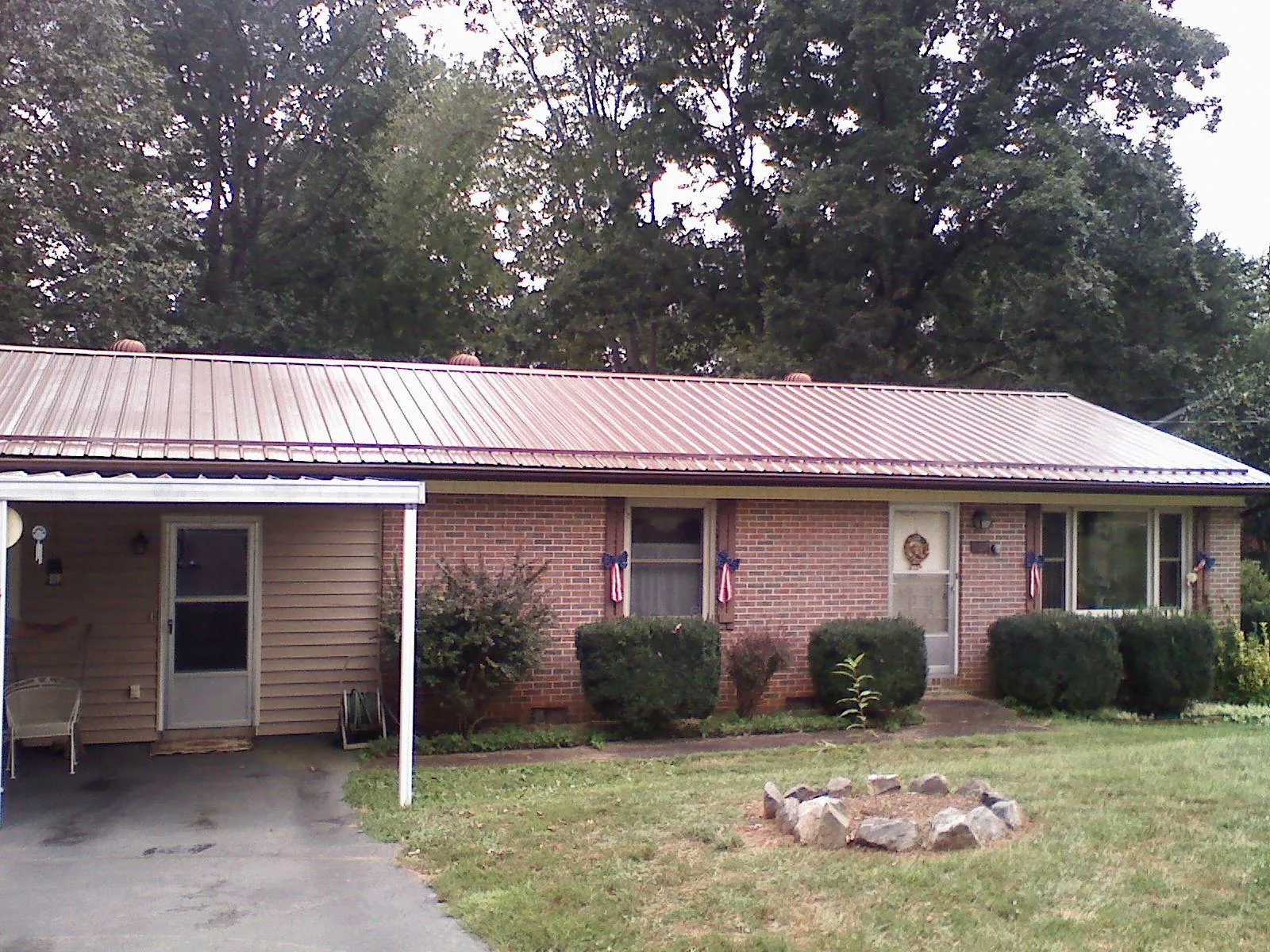 Bronze metal roof and carport on a brick ranch home — Roof Repair work by our crew in Tulare
