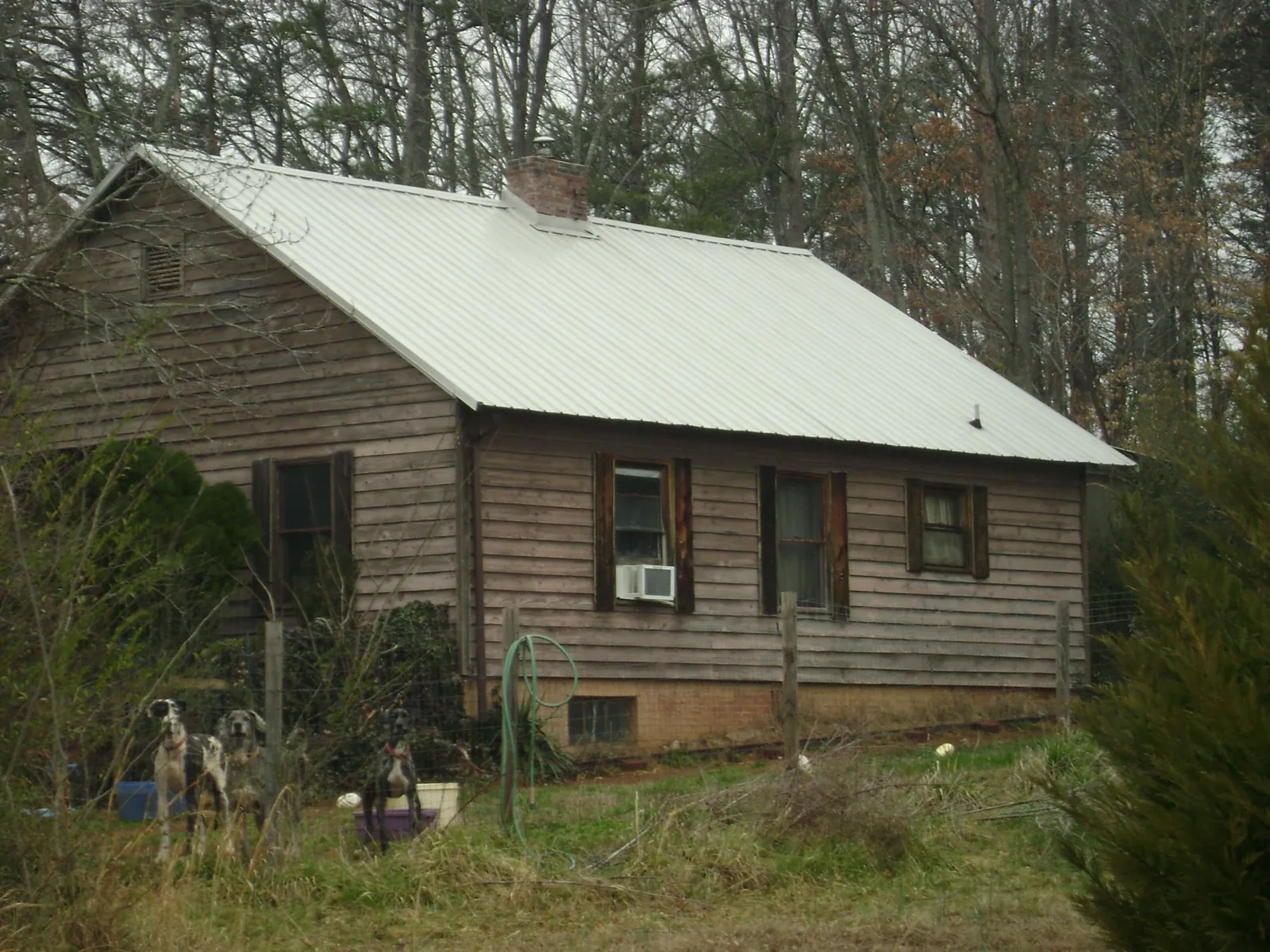 White metal roof on an old wood sided farmhouse, from a Metal Roof Installation job in Tulare